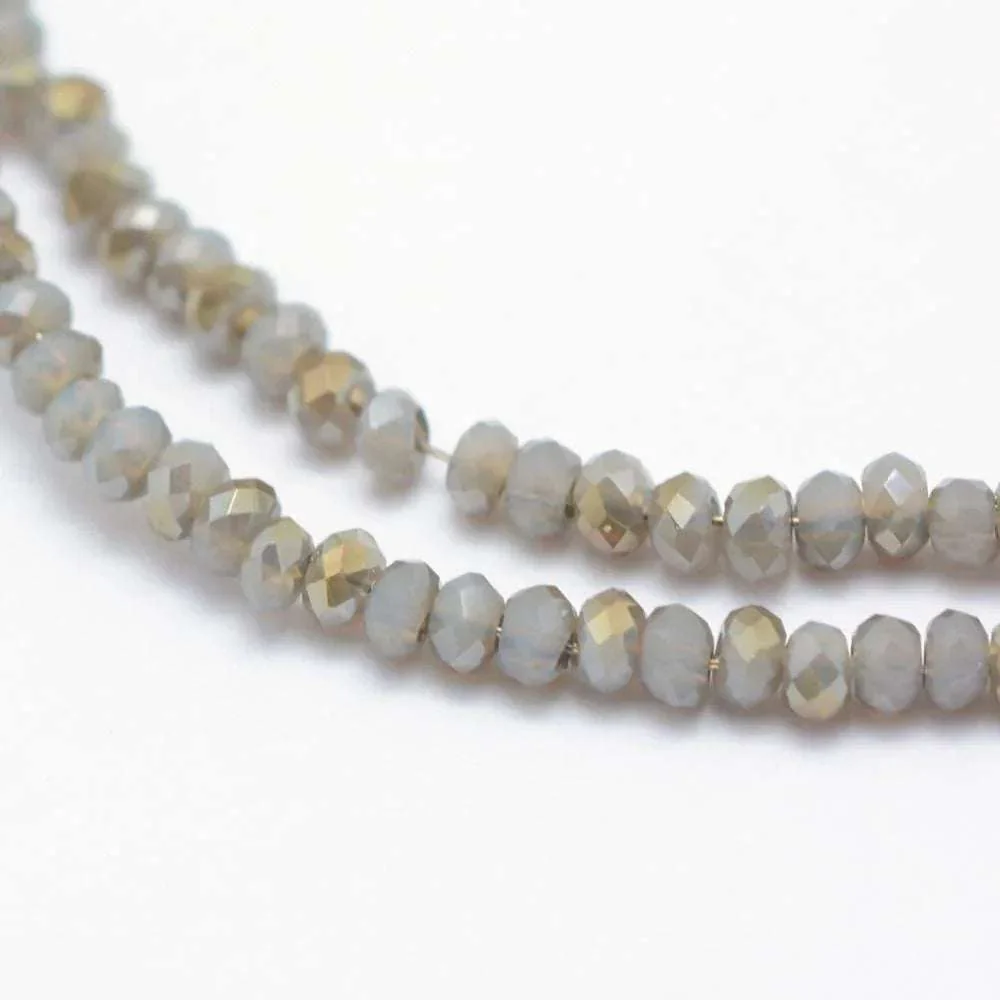 Facetterade glaspärlor - Grå med gröntlyster 2,5x1,5mm 1 sträng