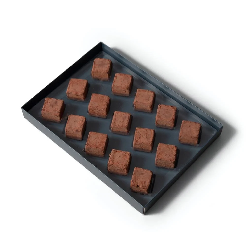 Chokladask med krämiga tryfflar av hasselnötsnougat i lakrits